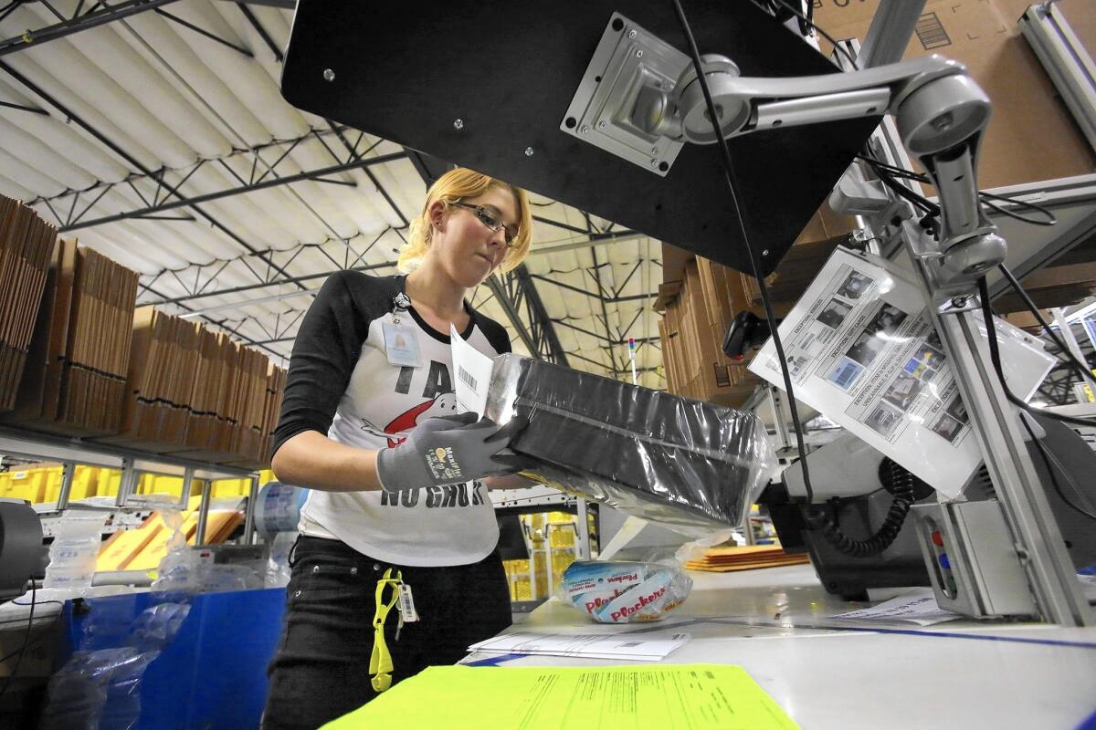 A worker fills an order at Amazon’s fulfillment center in San Bernardino.