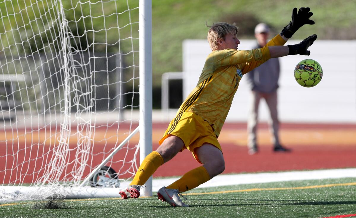 Edison boys' soccer goalie Bennett Flory stops a penalty kick after regulation in the Hawks Invitational championship match versus Manhattan Beach Mira Costa on Saturday.