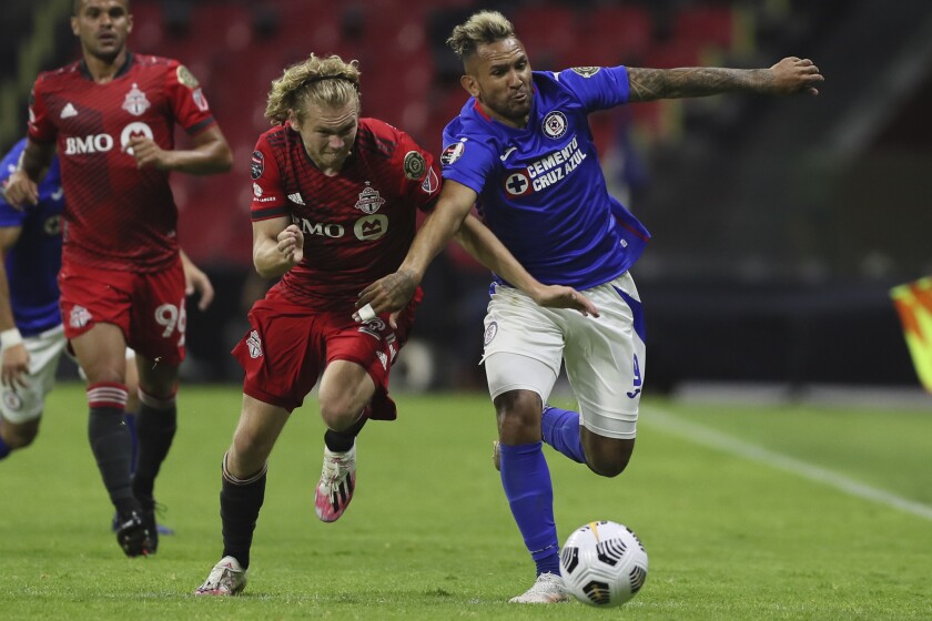 Walter Montoya of Mexico's Cruz Azul, right, and Jacob Shaffelburg of Canada's Toronto FC fight for the ball during CONCACAF Champions League quarterfinal second leg soccer match at Azteca stadium in Mexico City, Tuesday, May 4, 2021. (AP Photo/Fernando Llano)