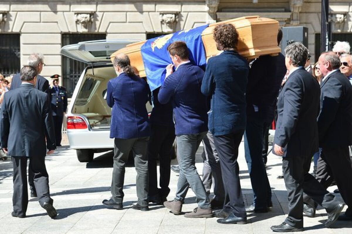 The coffin of designer Ottavio Missoni is carried by pallbearers from the Santa Maria Assunta Church in Gallarate, Itlay, on Monday.