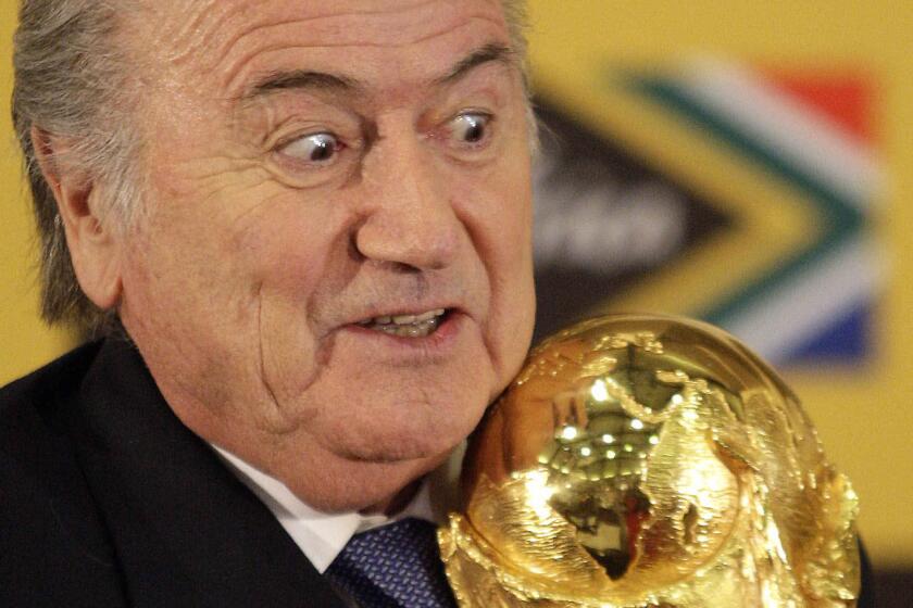 FIFA President Sepp Blatter holds the World Cup trophy during a media briefing on the 2010 Soccer World Cup in Pretoria, South Africa.