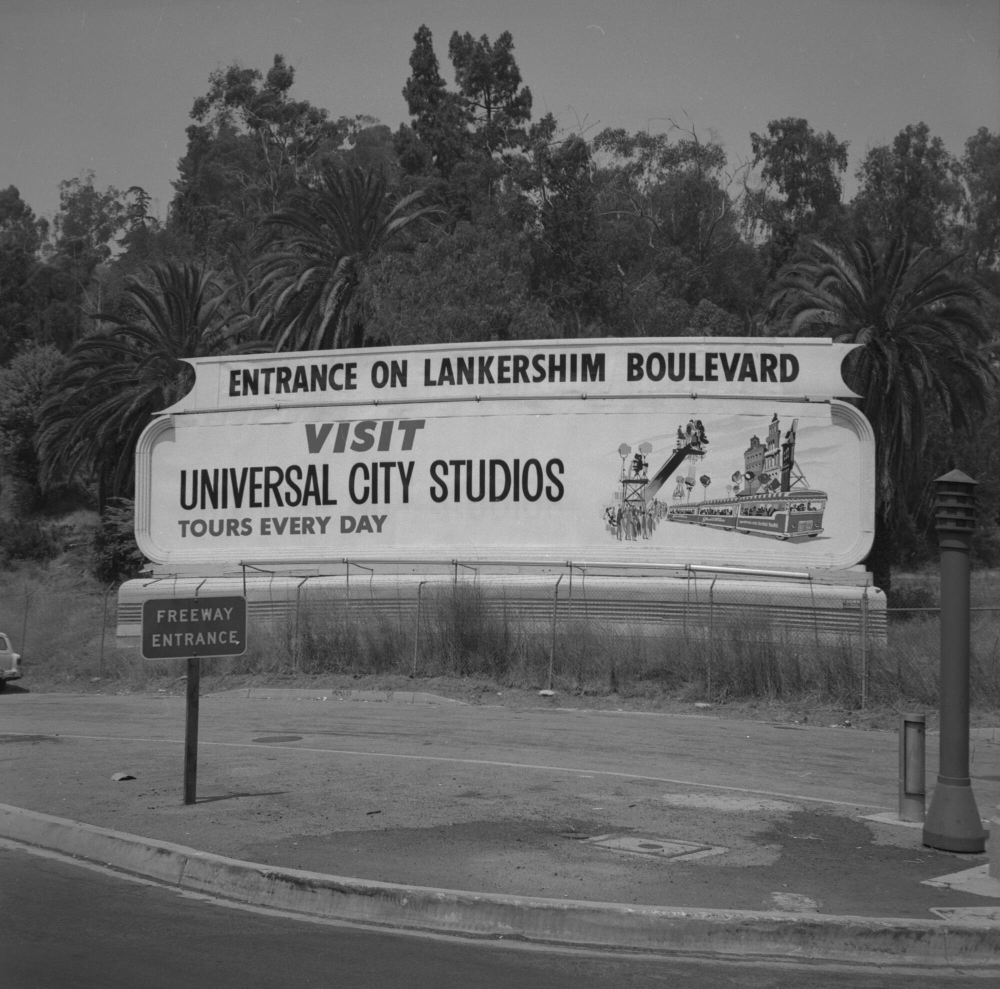 A roadside sign reads, "Visit Universal City Studios."