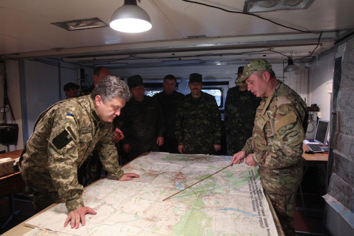 Ukrainian President Petro Poroshenko, left, examines a map at a military base close to Slovyansk, in eastern Ukraine.