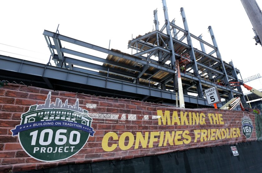 In this Tuesday, March 24, 2015, photo, renovations to Wrigley Field’s left field bleachers and the addition of a jumbo video screen continue in Chicago. When fans arrive for the Chicago Cubs’ baseball season opener Sunday, April 5, 2015, against the archrival St. Louis Cardinals, they will get the