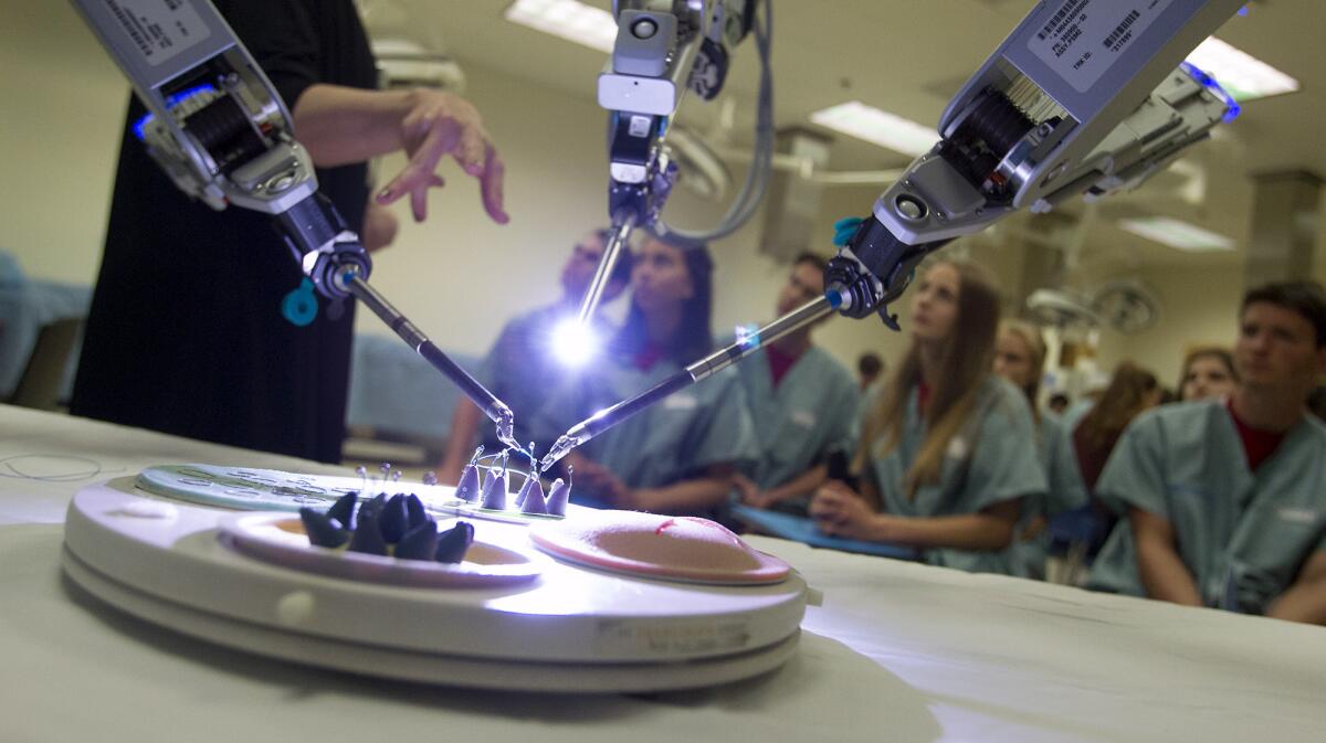 Corona del Mar High School Future Doctors Club members get a hands on demonstration of a da Vinci surgical robot at UCI Medical Center in Orange on Tuesday.