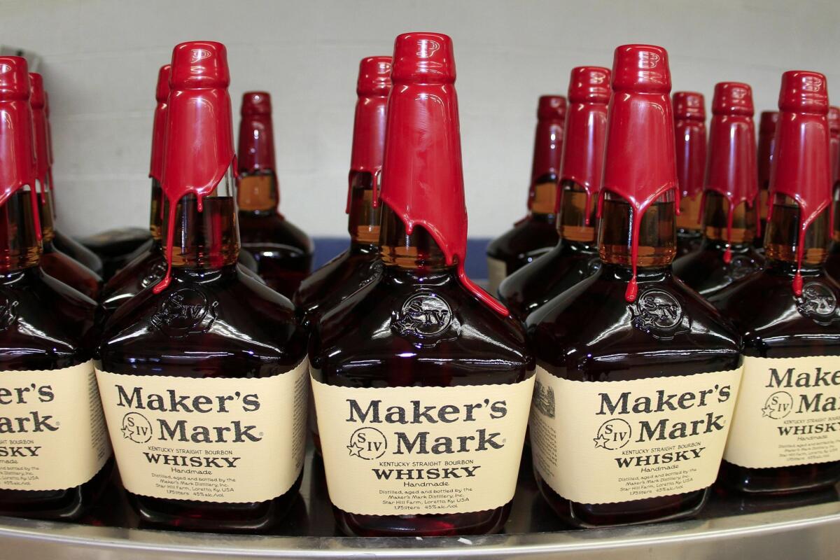 Bottles of Maker's Mark Distillery Inc. bourbon whisky sit on a conveyor belt after being hand dipped with their signature red wax at their distillery in Loretto, Kentucky, U.S., on Tuesday, Jan. 4, 2011.