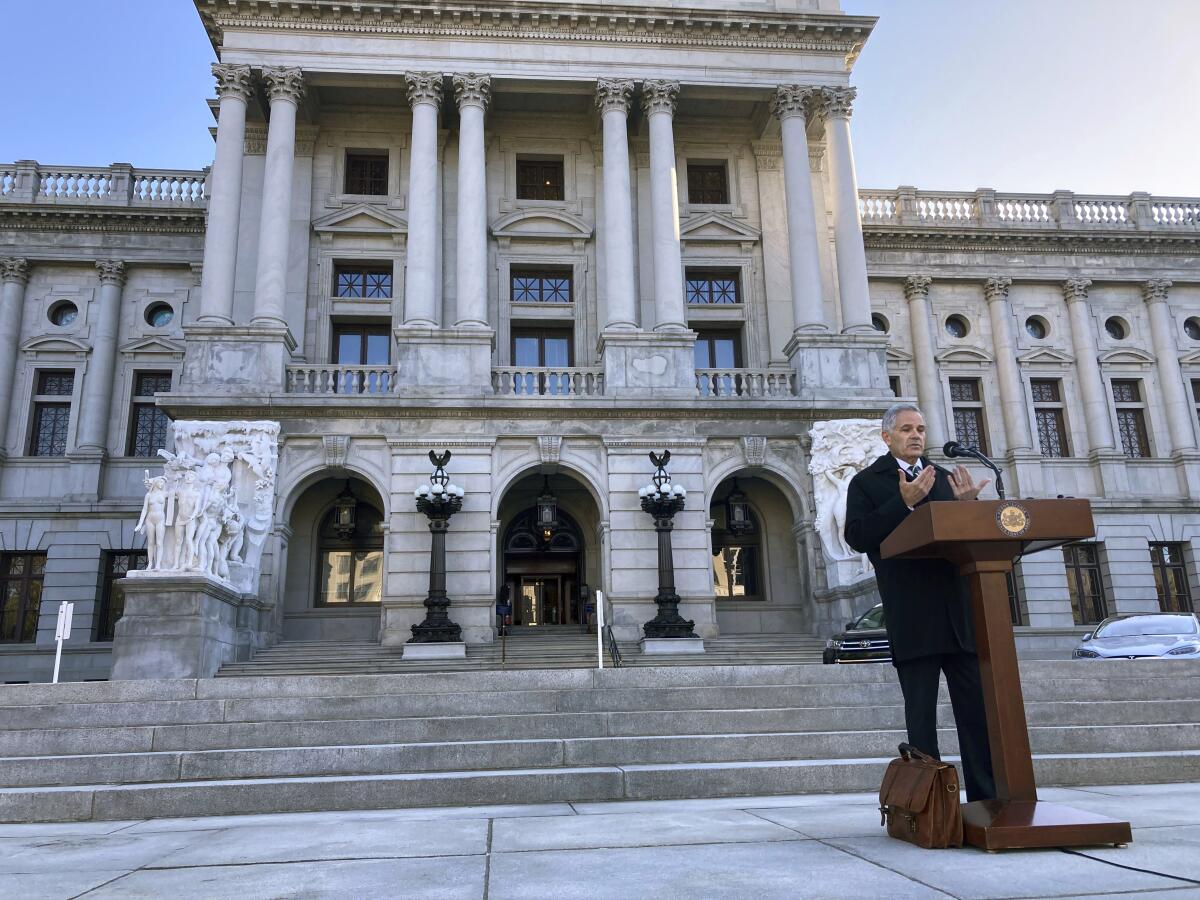A man speaks at a lectern outside the Pennsylvania Capitol 