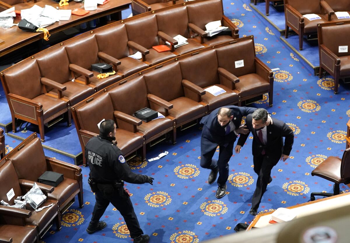 Members of Congress run for cover as Trump-incited insurrectionists try to enter the House chamber in the Capitol.