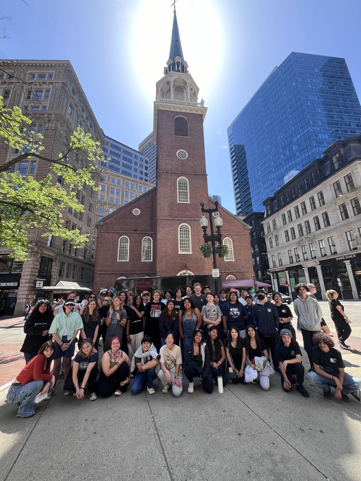 The Newport Harbor wind ensemble and orchestra pose in front of the Old South Meeting House.