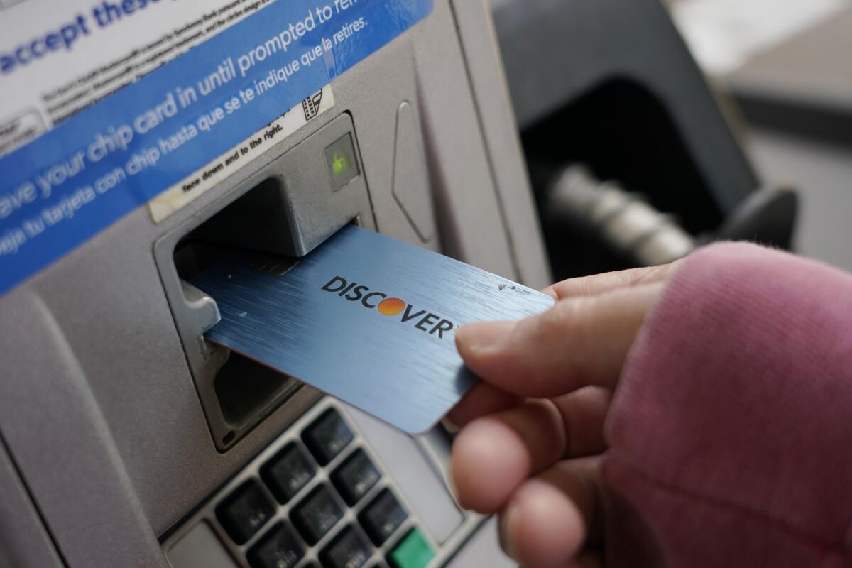 A Discover card is inserted into a gas pump credit-card reader