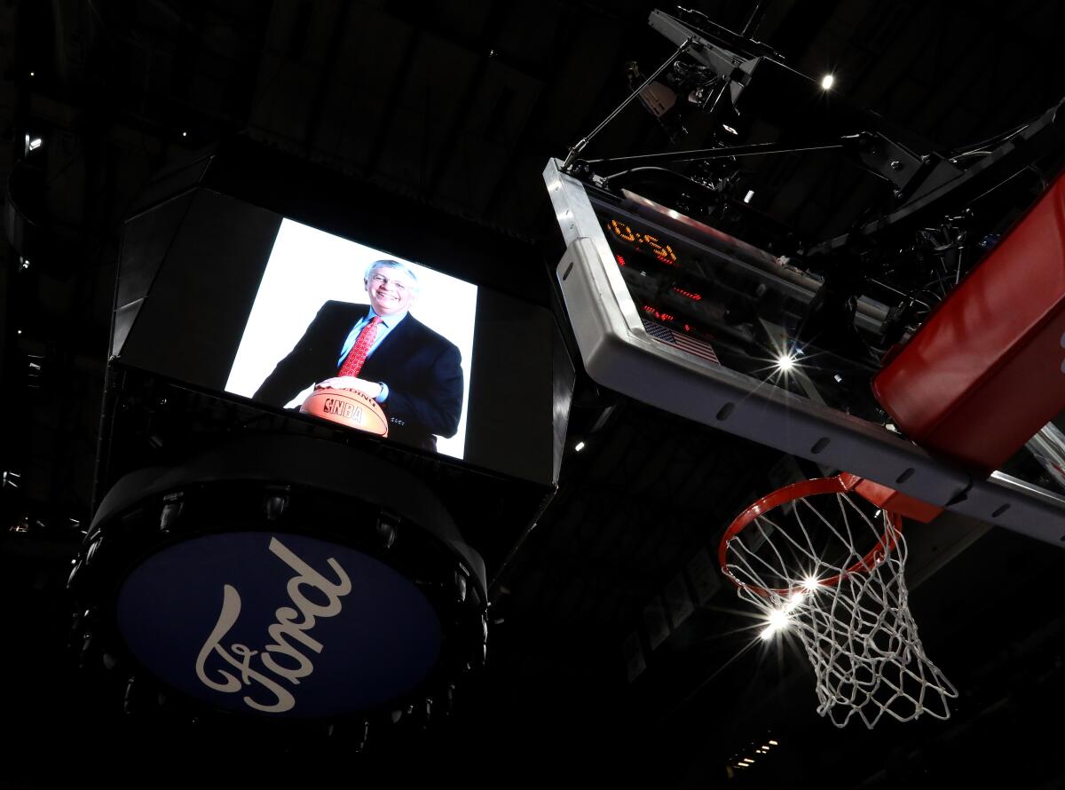 A photo of former NBA commissioner David Stern on the scoreboard, a basketball hoop and the Ford logo can be seen in a photo looking up toward the ceiling of the American Airlines Arena.