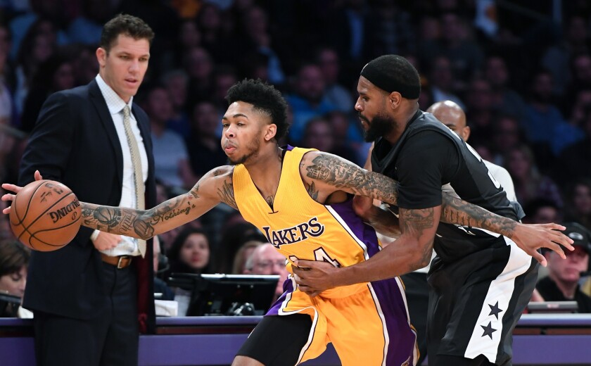 Brandon Ingram of the Lakers is fouled by Trevor Booker of the Nets on Tuesday as Lakers Coach Luke Walton looks on.