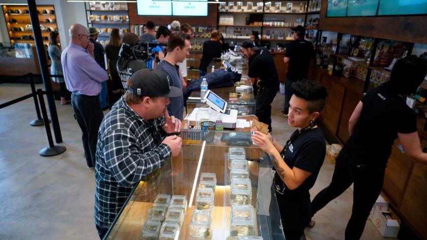 On the first day of recreational marijuana sales in San Diego, Genesiee Cervantes with Urbn Leaf assisted Billy Johnson with his selections.