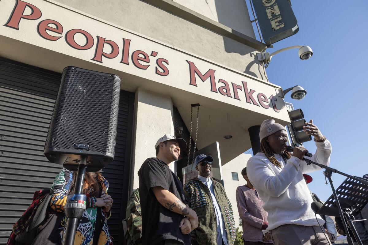 People stand outside People's Market