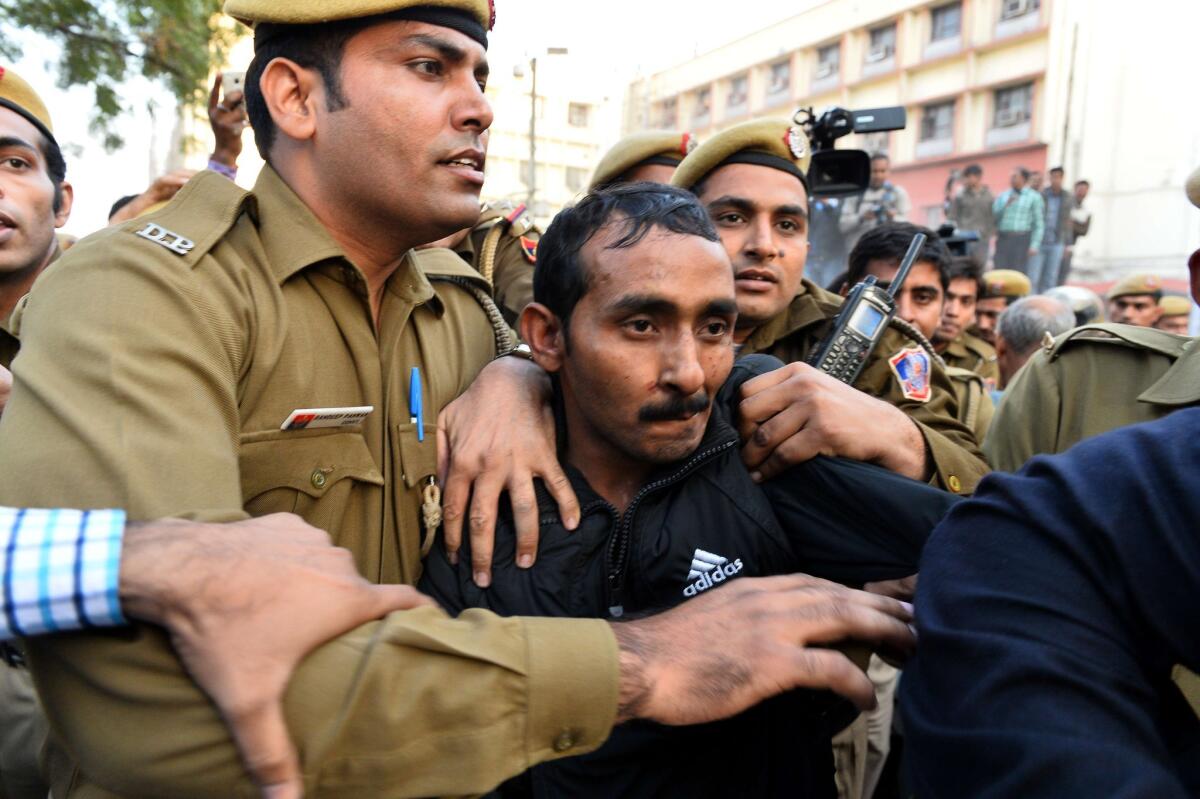 Shiv Kumar Yadav is escorted by police after a court appearance in New Delhi on Dec. 8, 2014.
