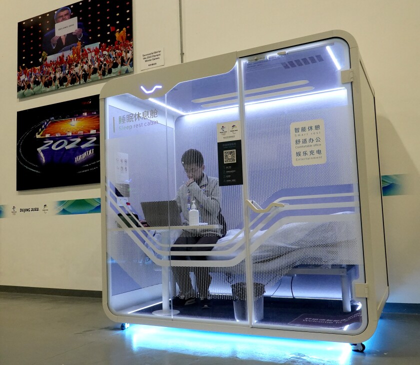 Bai Wenshuo works on his laptop in a sleep cabin.