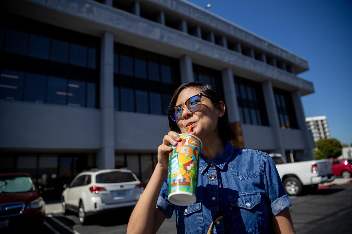 Kim Nguyen drinks a fruit smoothie outside 
