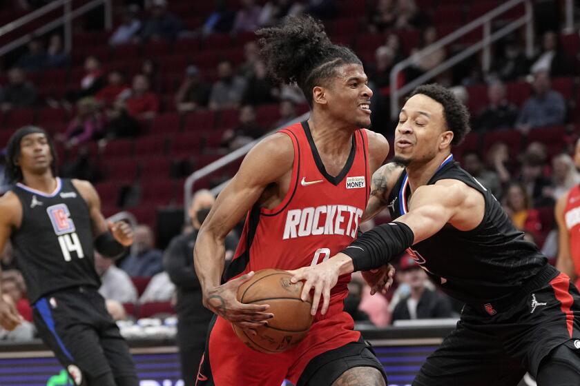 Los Angeles Clippers' Amir Coffey, right, reaches for the ball as Houston Rockets' Jalen Green (0) drives toward the basket during the first half of an NBA basketball game Tuesday, March 1, 2022, in Houston. (AP Photo/David J. Phillip)