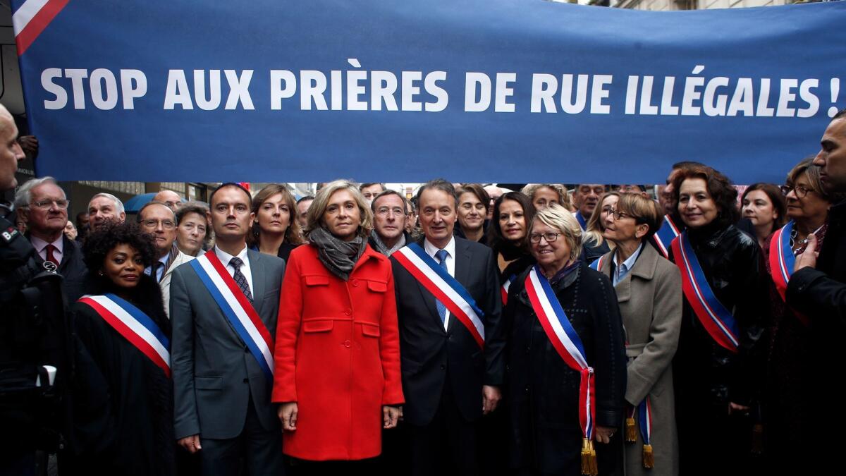 Clichy la Garenne's mayor Remi Muzueau, center right, and President of the Regional Council of the Ile-de-France region Valerie Pecresse, center left, demonstrate against Muslim street prayers, in the Paris suburb of Clichy la Garenne, Friday, Nov. 10, 2017.