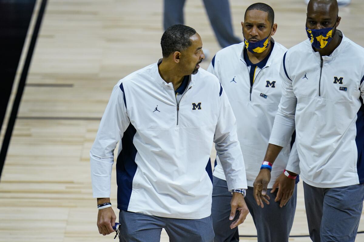 Michigan coach Juwan Howard, left, leaves the court after he was ejected from the game March 12, 2021.