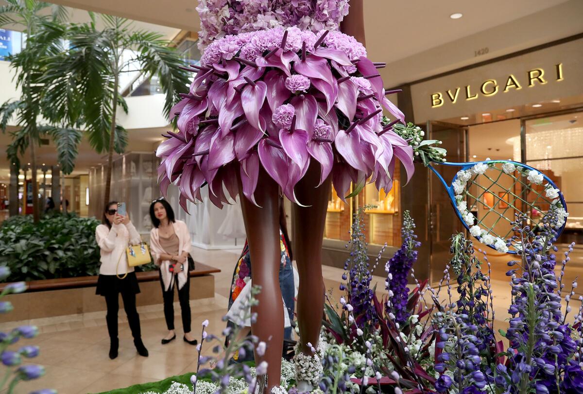 Guests look at the flower figure of tennis star Serena Williams at the Fleurs de Villes FEMMES, floral exhibit in 2022.