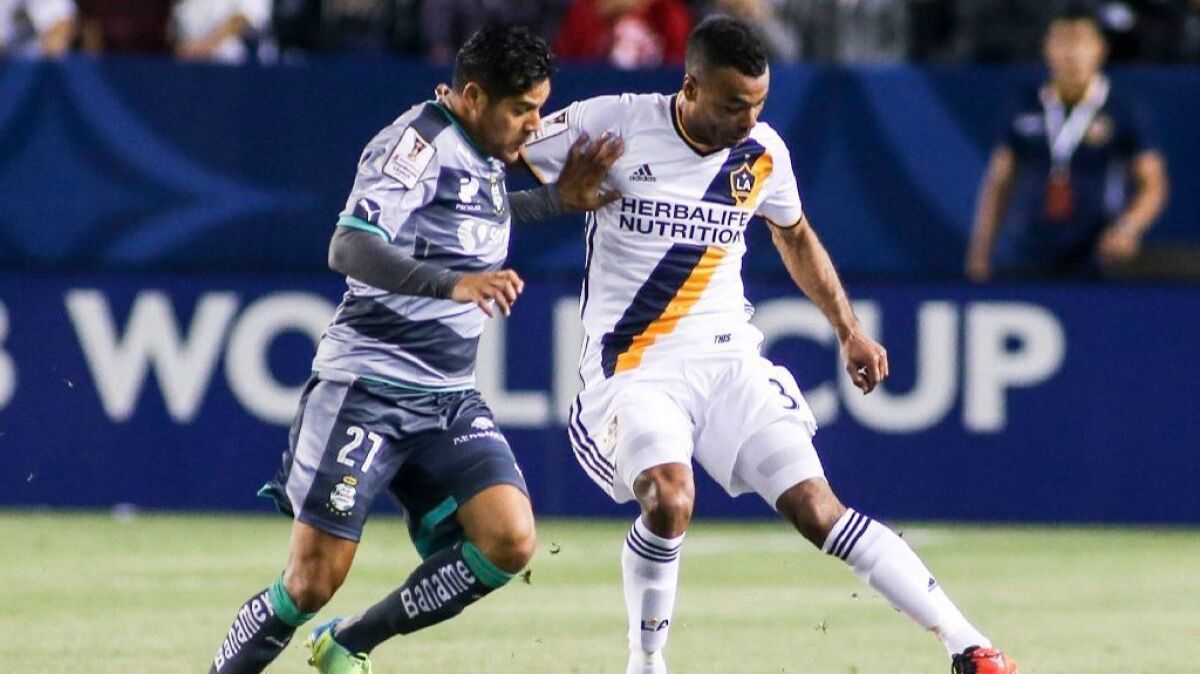Galaxy defender Ashley Cole, right, here working against Santos Laguna forward Javier Orozco last year, is expected to sit out a month after suffering a calf strain during a scrimmage.