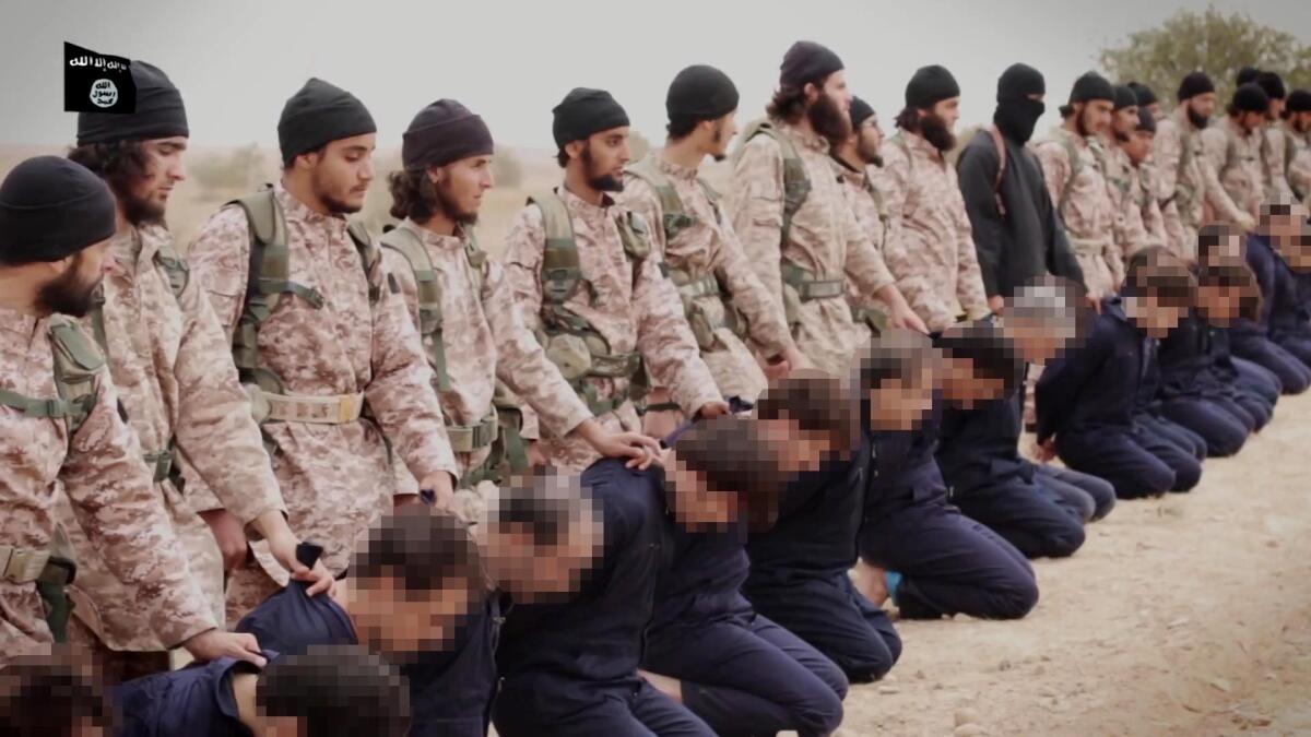 An image grab from a propaganda video released Sunday shows Islamic State extremists preparing to execute 15 Syrian soldiers.