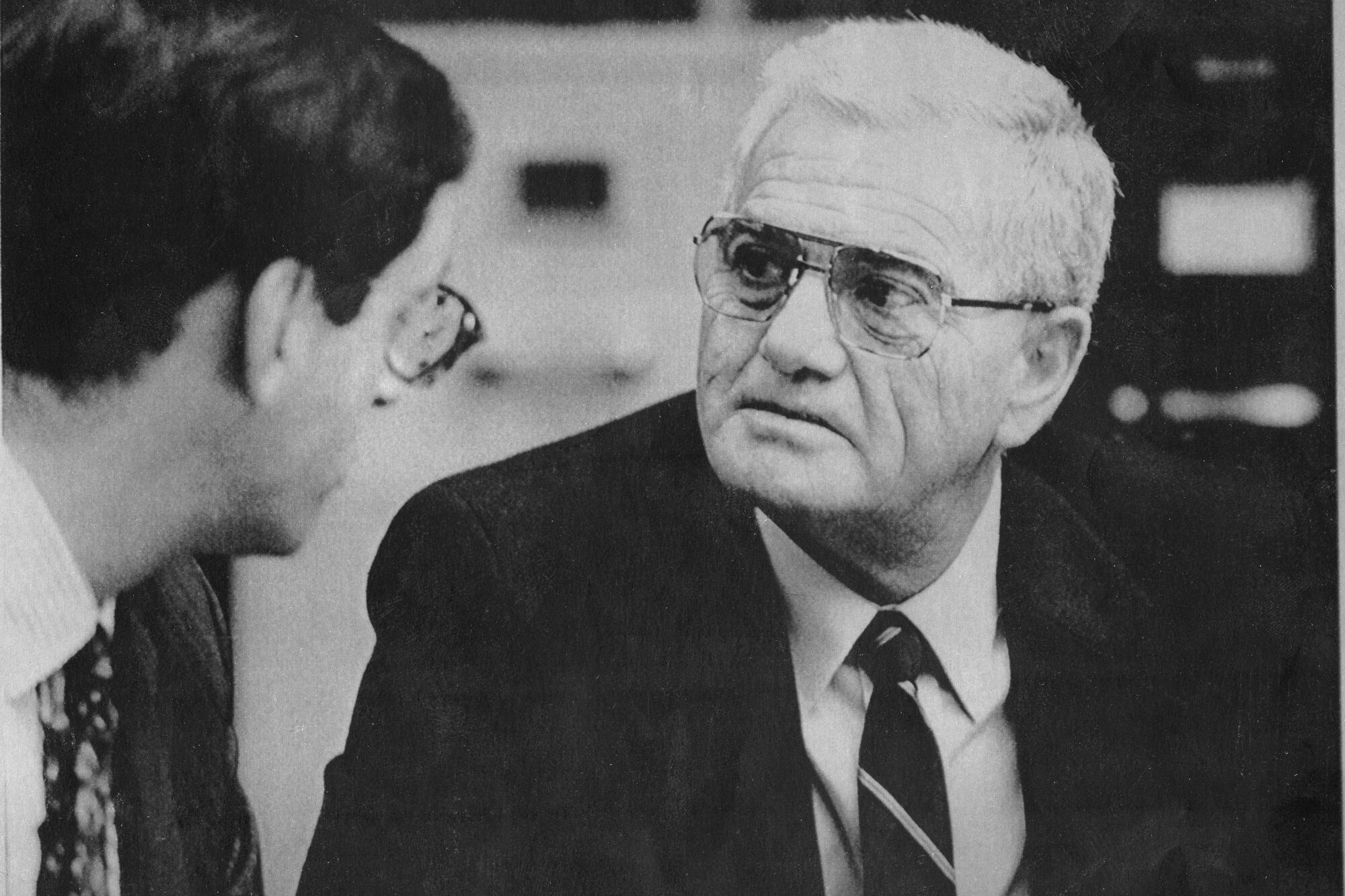 A black-and-white photo of George Franklin seated and talking with lawyer Douglas Horngrad, seen in profile