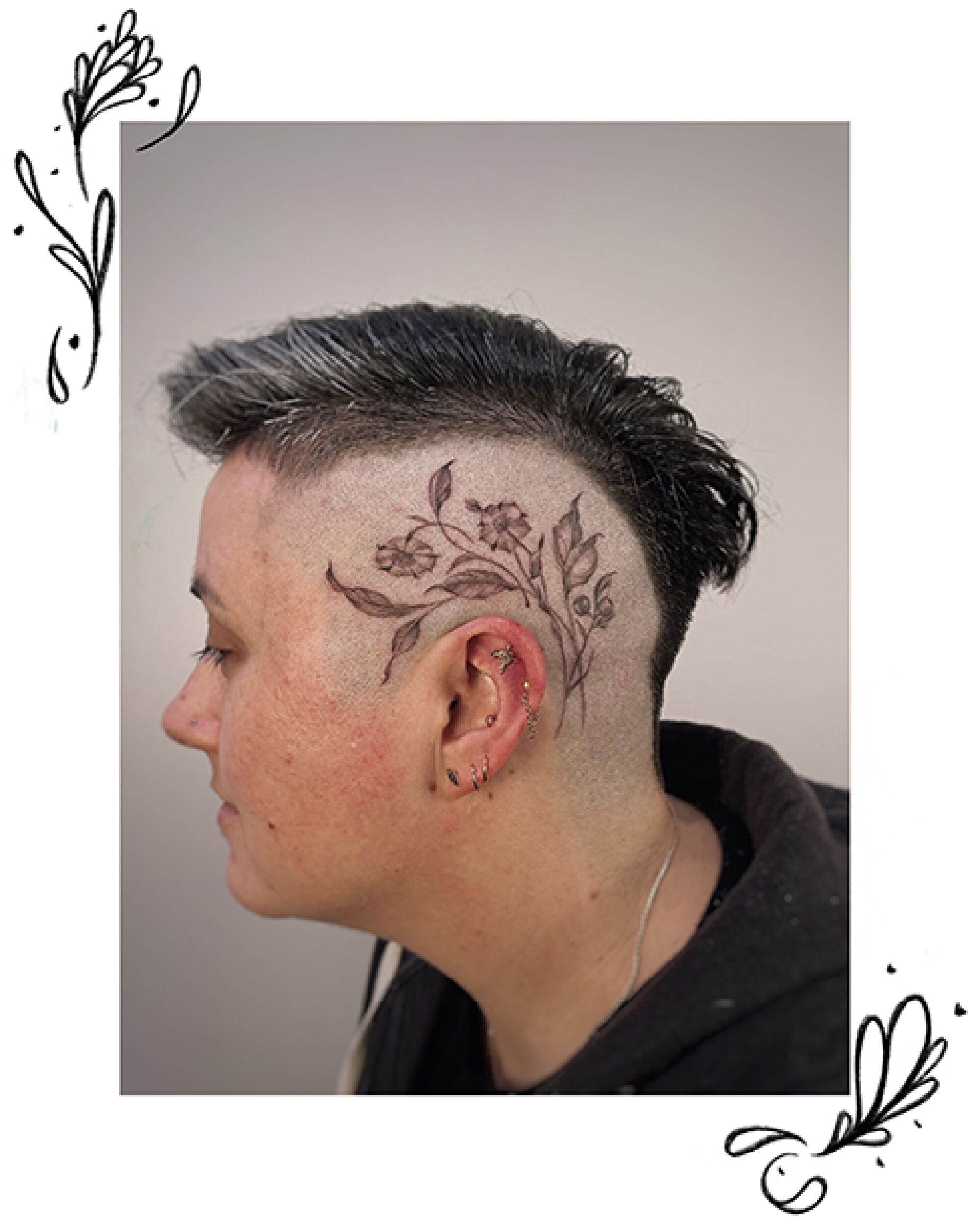 Leaves, flowers tattooed on the side of a head. 