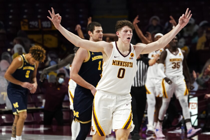Minnesota's Liam Robbins (0) celebrates his three-point shot against Michigan in the second half of an NCAA college basketball game, Saturday, Jan. 16, 2021, in Minneapolis. (AP Photo/Jim Mone)