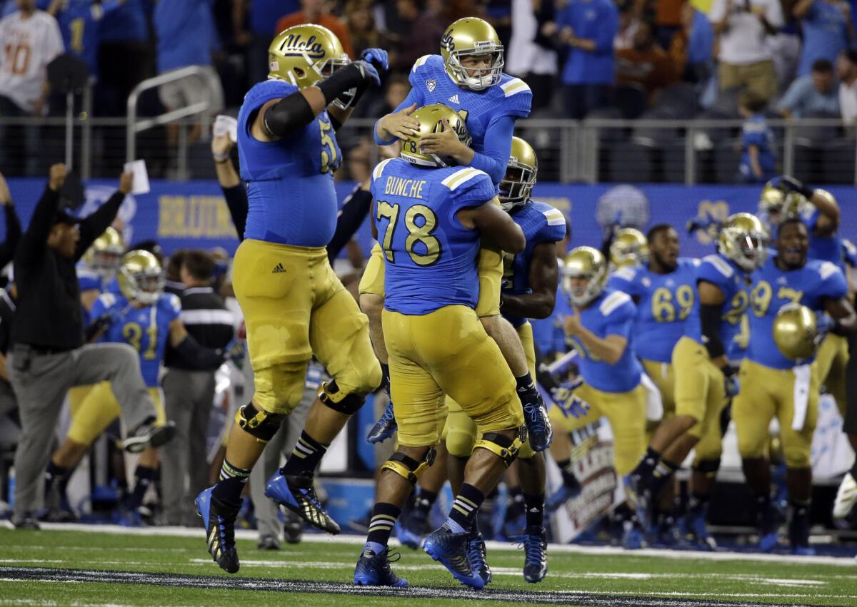 UCLA offensive linesman Alex Redmond, left, celebrates as Malcolm Bunche lifts Jerry Neuheisel after UCLA scored a late touchdown against Texas on Sept. 13.