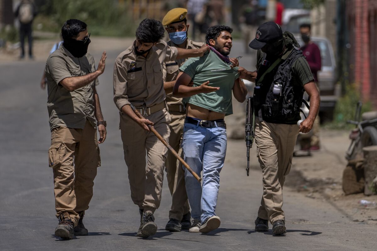 Policemen detain a minority Hindus, locally known as Pandits, during a protest march against the killing of Rahul Bhat, also a Pandit, on the outskirts of Srinagar, Indian controlled Kashmir, Friday, May 13, 2022. Hindus in Indian-controlled Kashmir staged protests on Friday a day after assailants shot and killed the government employee from the minority community. It was the first time that Pandits, an estimated 200,000 of whom fled Kashmir after an anti-India rebellion erupted in 1989, simultaneously organized street protests at several places in the Muslim-majority region. (AP Photo/Dar Yasin)