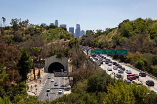 Traffic on the Arroyo Seco Parkway and 110 Freeway with downtown Los Angeles in the background.