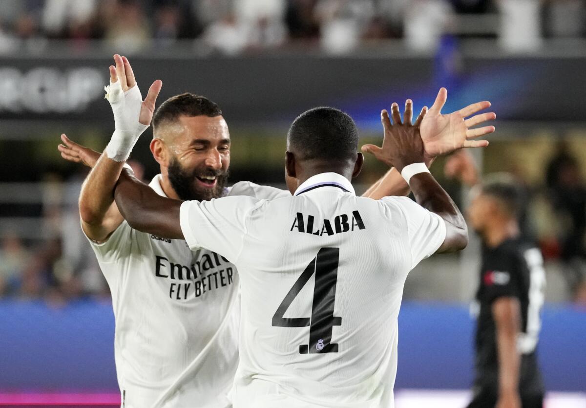 Real Madrid's David Alaba celebrates with Real Madrid's Karim Benzema after scoring his side's opening goal during the UEFA Super Cup final soccer match between Real Madrid and Eintracht Frankfurt at Helsinki's Olympic Stadium, Finland, Wednesday, Aug. 10, 2022. (AP Photo/Sergei Grits)