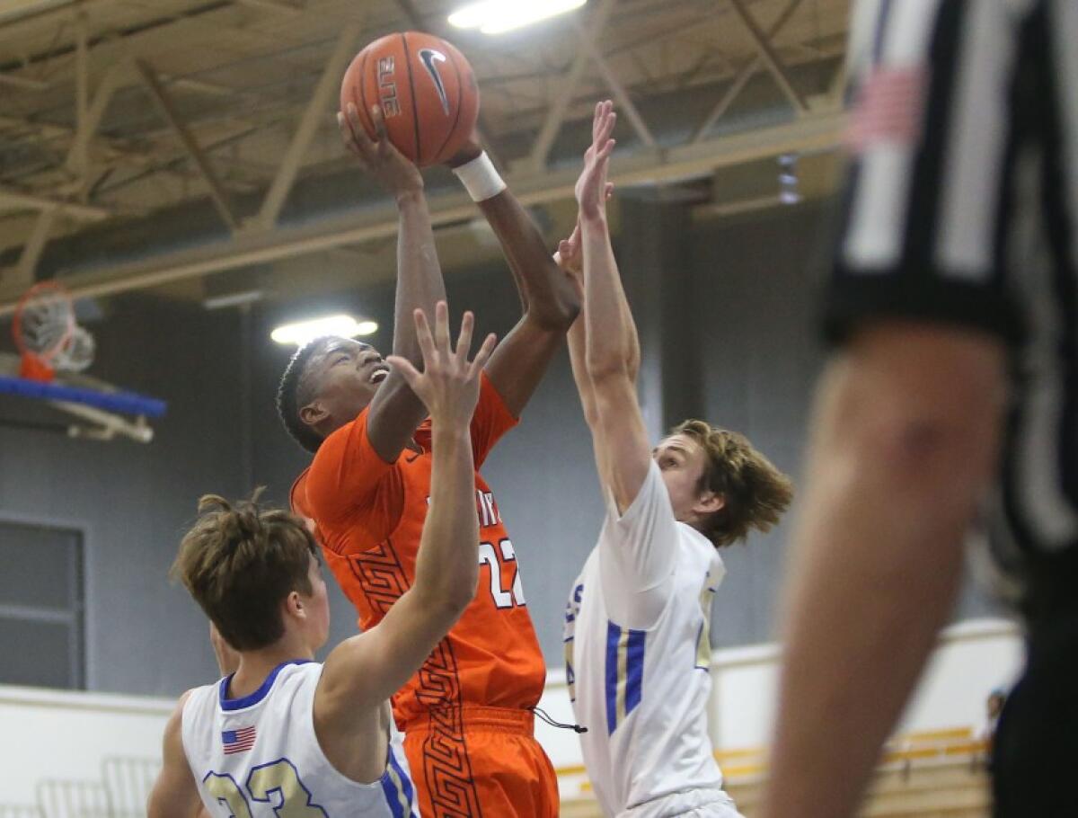 Pacifica Christian Orange County’s Judah Brown drives between Santa Margarita’s Jake Heberle, left, and Jack McCloskey during a nonleague game on Nov. 19, 2019.