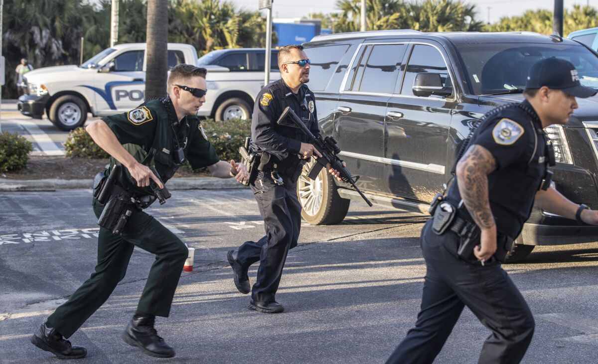 Armed police respond to a report of a suspect with a gun near the scene of a shooting at Waffle House in Panama City Beach, Fla., Sunday, March 27, 2022. Two Alabama men are accused of inciting or encouraging a riot after authorities said messages were spread online encouraging the spring break “takeover” of a Florida beach town, authorities said. (Mike Fender/News Herald via AP)