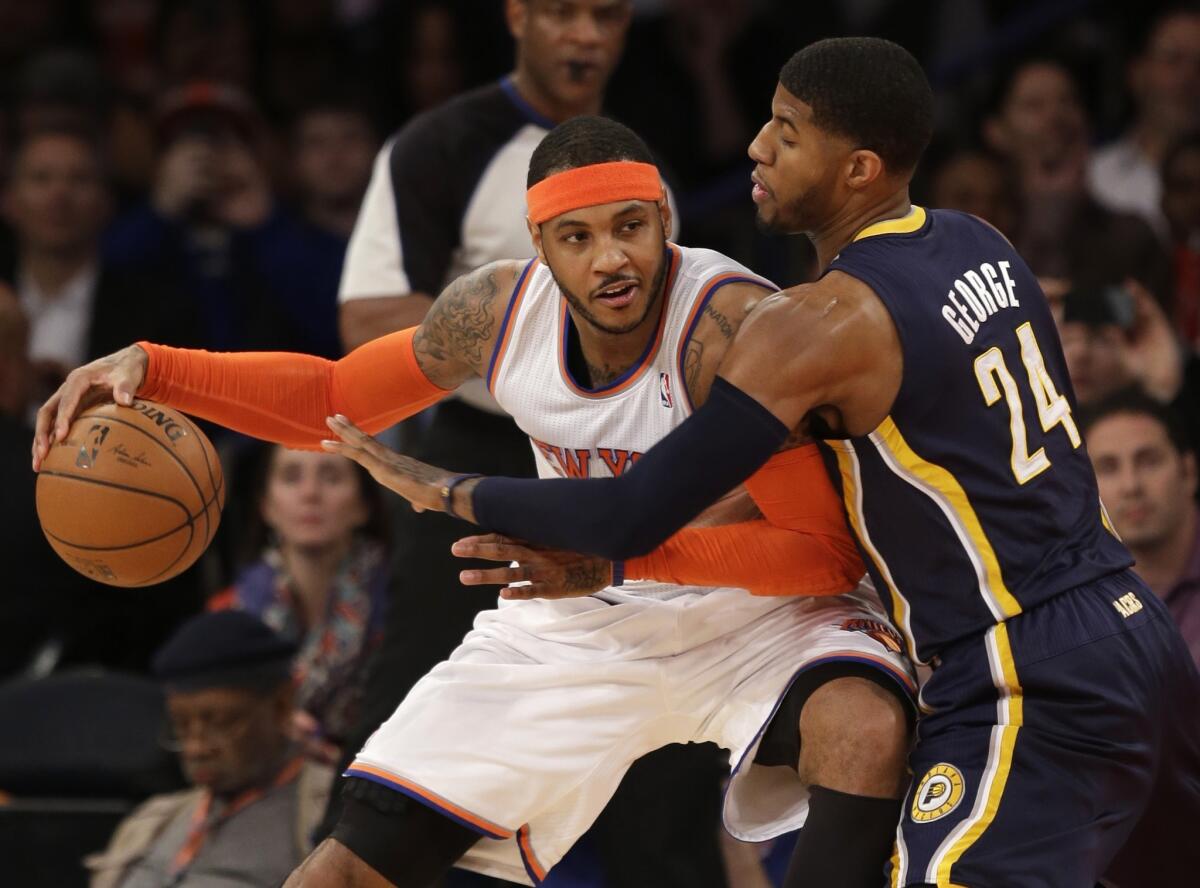 Carmelo Anthony, here trying to move around the Indiana Pacers' Paul George back in March, is reportedly staying put in New York.