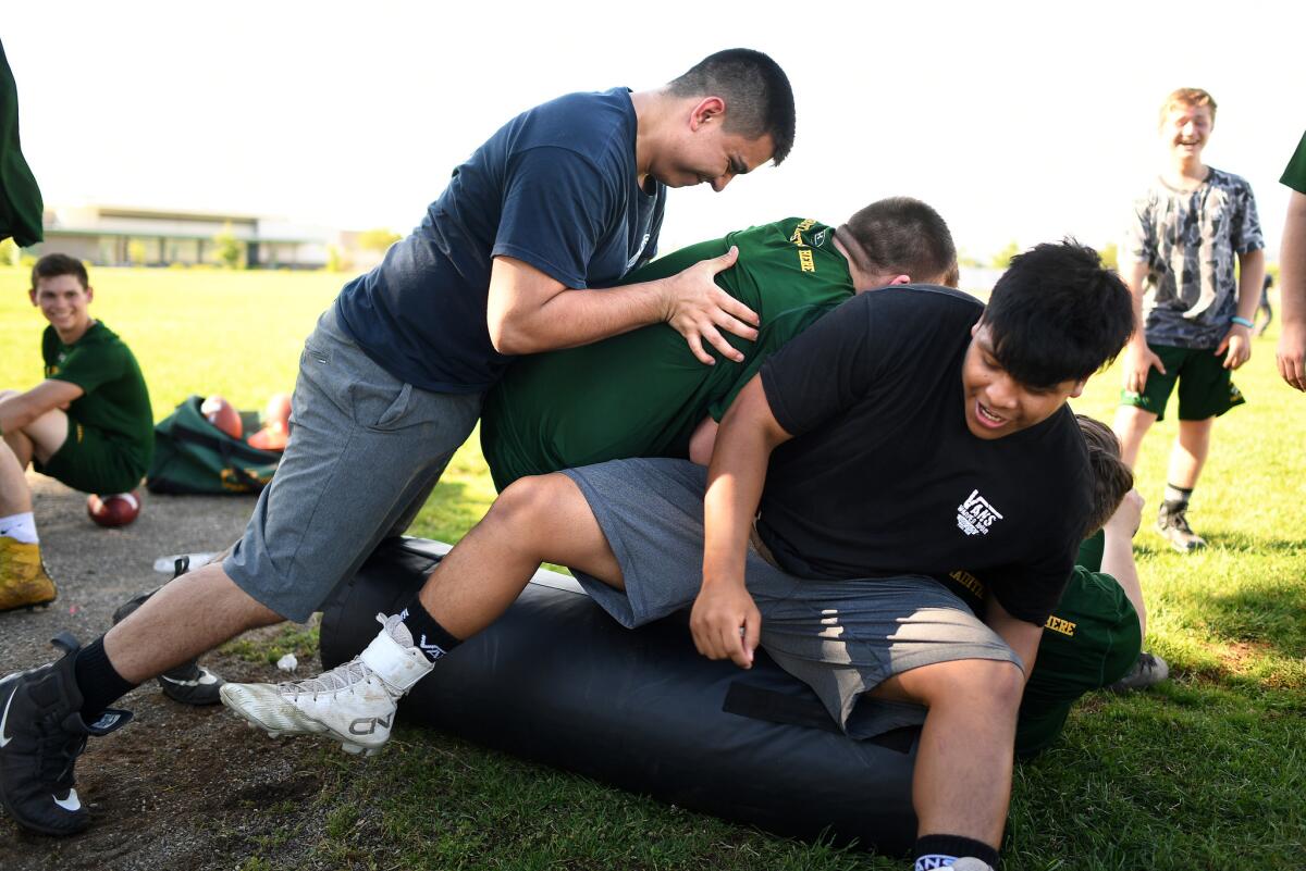 Paradise football players play around during a break during spring practice at Marsh Junior High in Chico.