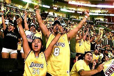 Kimberly Sotelo, 10, and her father, Tony Sotelo, celebrate a Lakers basket as they watch a broadcast of the game at Staples Center in Los Angeles.