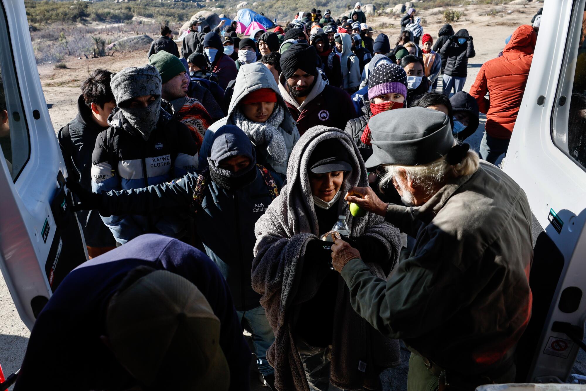 Migrants line up for donated food. 