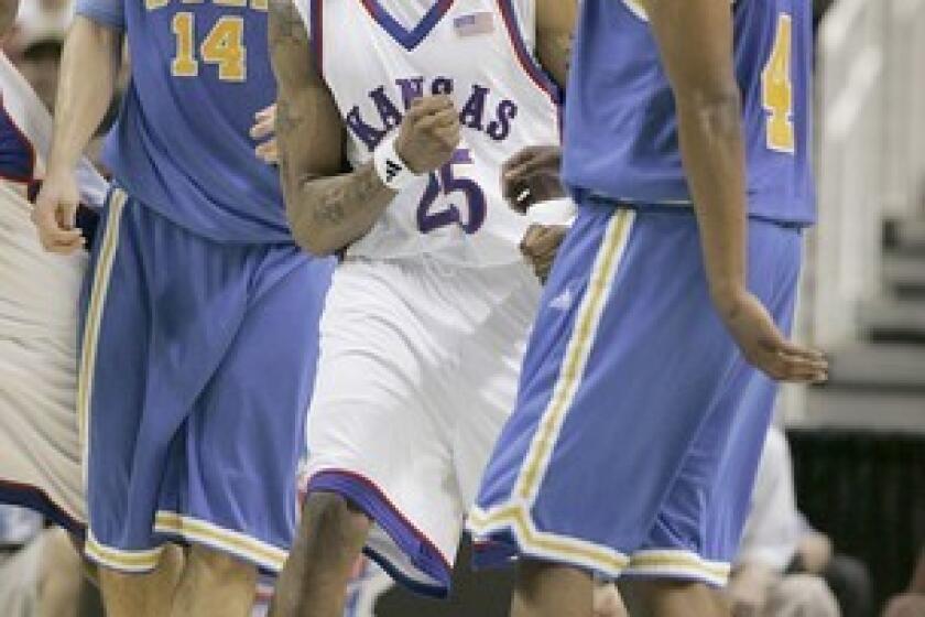 Kansas' Brandon Rush reacts after a foul is called while standing between UCLA's Lorenzo Mata and Arron Afflalo during the NCAA West Regional final Saturday at HP Pavilion in San Jose.