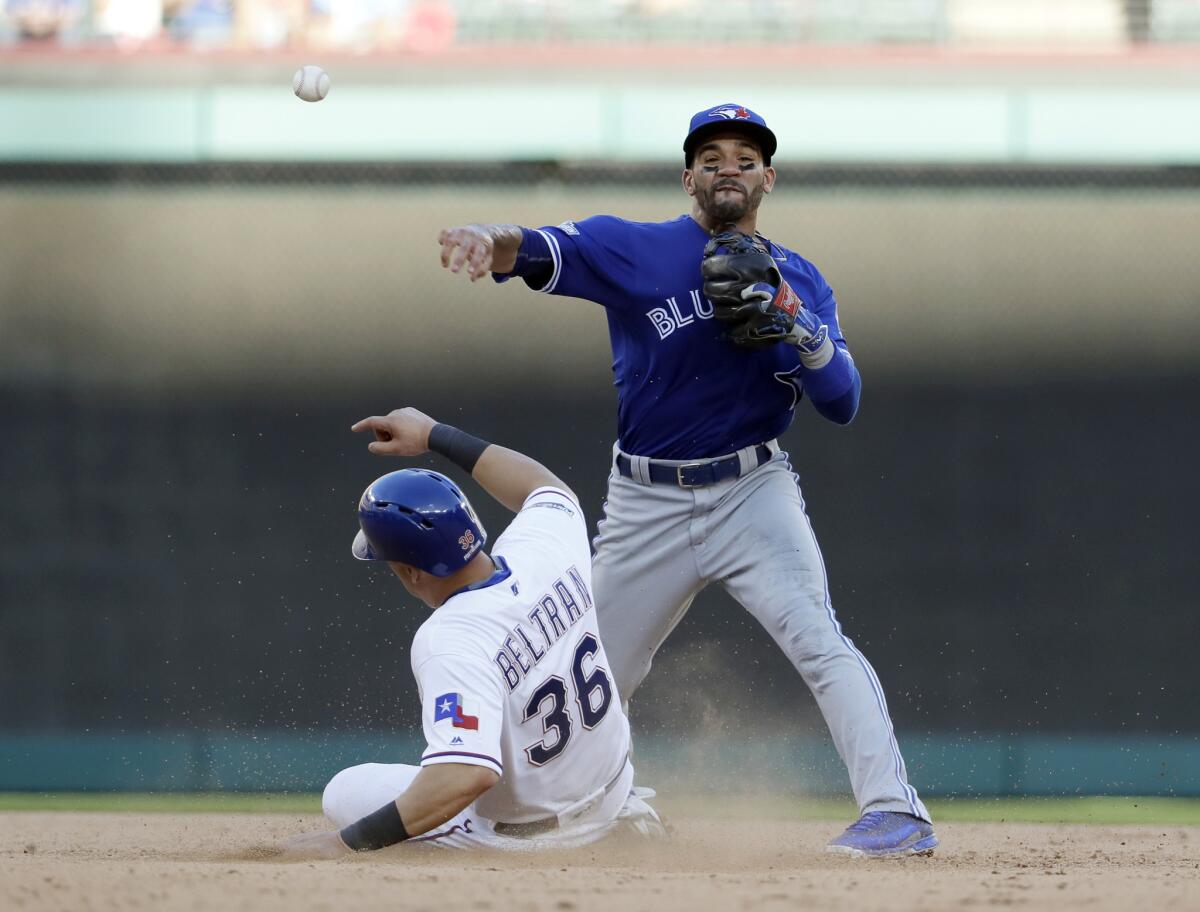 Blue Jays second baseman Devon Travis throws to first for the double play after forcing out Rangers' Carlos Beltran during the seventh inning of Game 1 of the ALDS on Oct. 6.