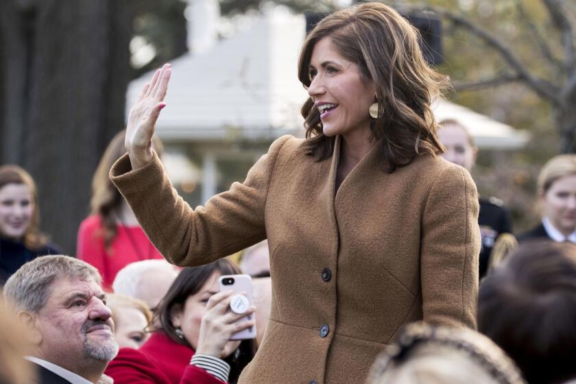 FILE - In this Tuesday, Nov. 20, 2018, file photo, South Dakota Gov.-elect Kristi Noem waves as she is recognized by President Donald Trump during a ceremony to pardon the National Thanksgiving Turkey in the Rose Garden of the White House in Washington. Supporters of legislation that would allow people to carry concealed handguns without a permit in South Dakota anticipate revived prospects for the conservative prize under Republican Gov.-elect Noem. (AP Photo/Andrew Harnik, File)