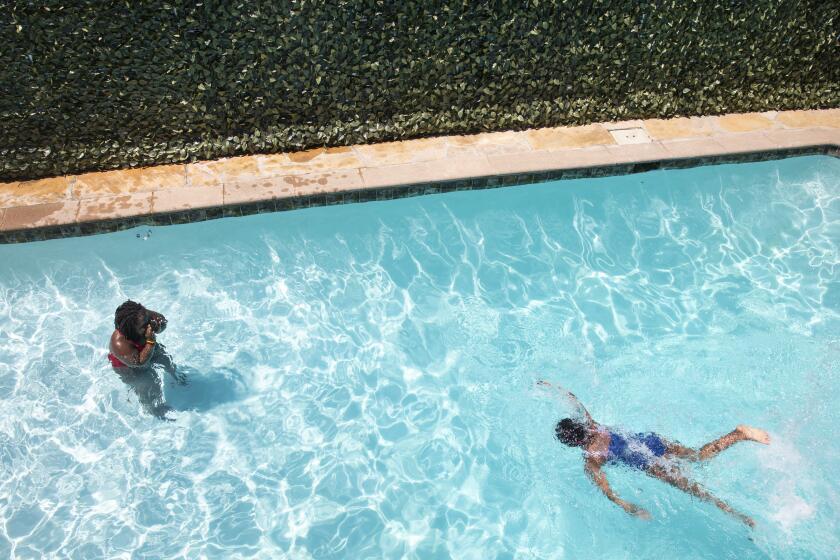 Los Angeles, CA - July 06: Harmony Taylor, 10, left, swims toward her teacher Symone Martin, at a friends pool in the Baldwin Hills neighborhood of Los Angeles, CA, Tuesday, July 6, 2021. Taylor and her siblings, Melody, 8, and Sam,2, have been taking 35-40 minute lessons with Martin for about three weeks. Martin has been teaching swimming for almost six years and finds herself in this pool Monday through Saturday with lessons. (Jay L. Clendenin / Los Angeles Times)