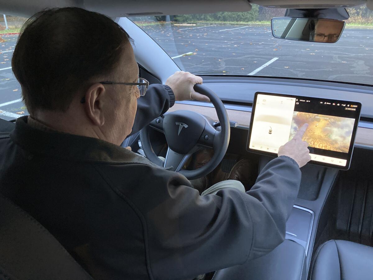 A man plays a video game while driving on a closed course.
