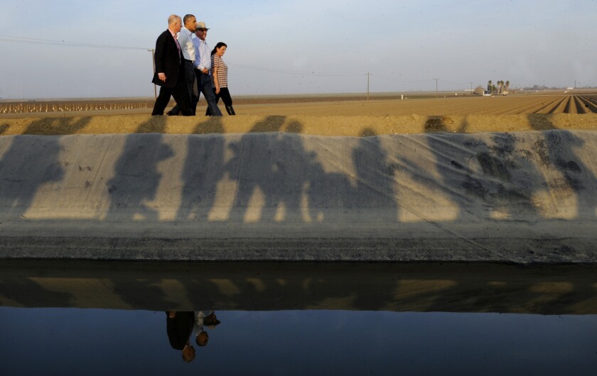 President Obama walks with California Gov. Jerry Brown, left, and a farm couple while discussing effects of the state drought during a visit to Los Banos, Calif.