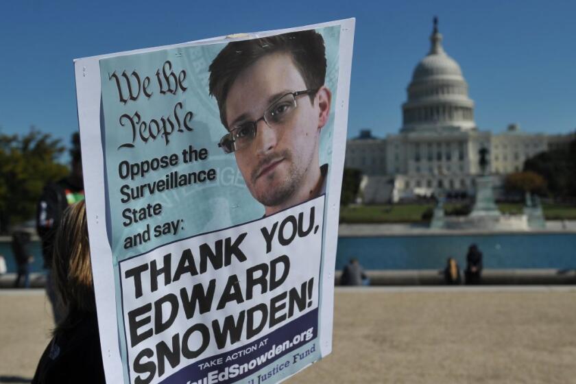 Demonstrators are seen holding placards supporting former U.S. intelligence analyst Edward Snowden.