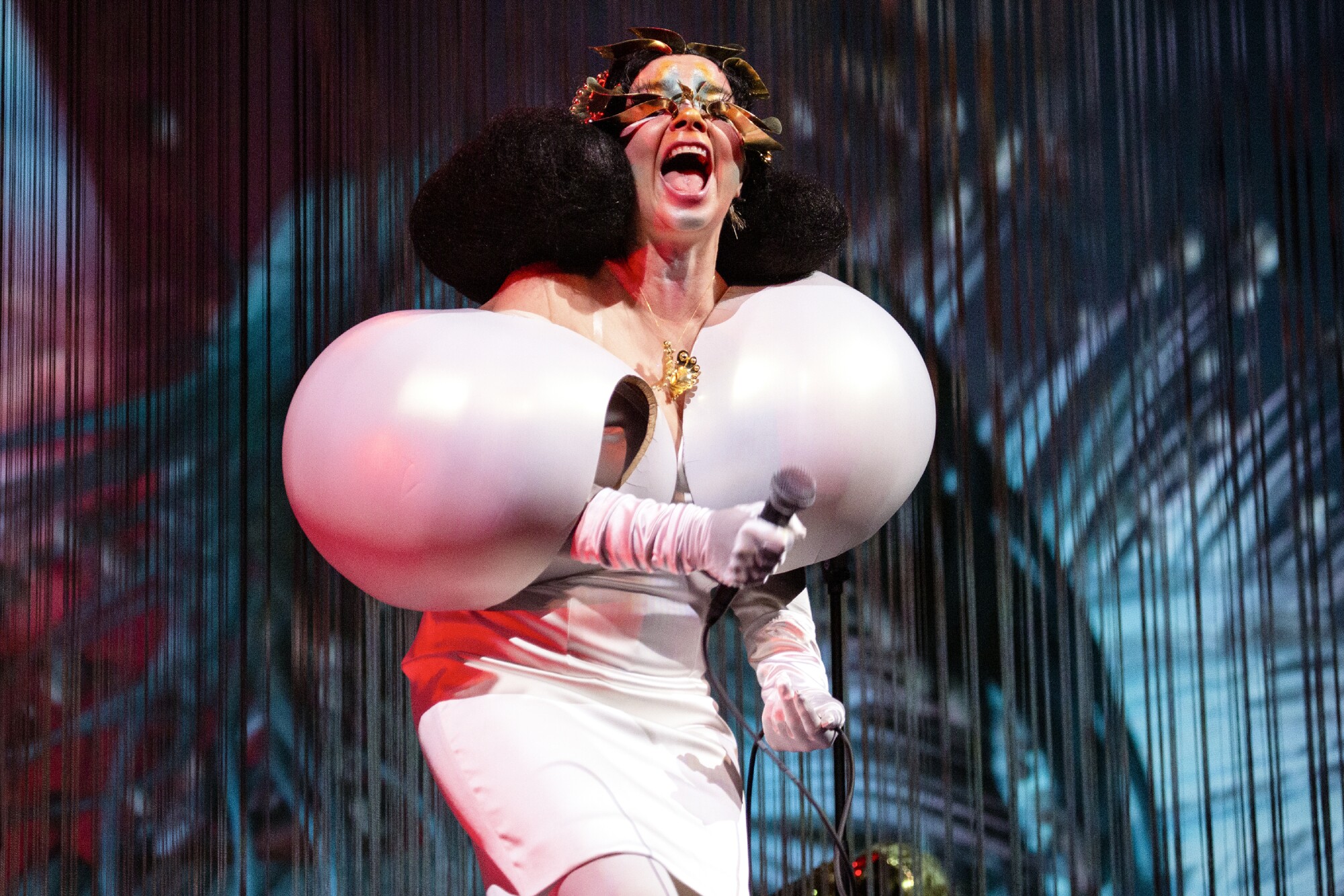 A woman performs onstage in a white inflatable dress.
