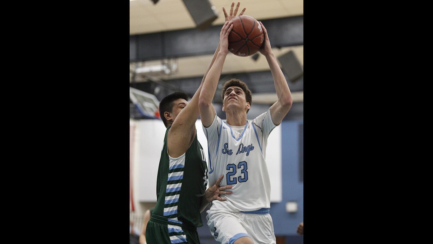Corona del Mar's Kevin Kobrine goes up for shot against Irvine's Eugene Reyes in a Pacific Coast League game on Thursday, January 18.