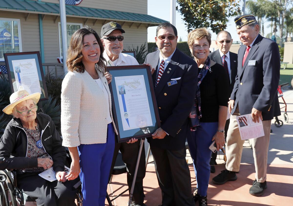 Honoree Bill Kull (Army), 99, third from left, accepts recognition from state Assemblywoman Cottie Petrie-Norris, second from left, during a ceremony honoring a dozen area veterans Friday at the Heroes Hall veterans museum in Costa Mesa.